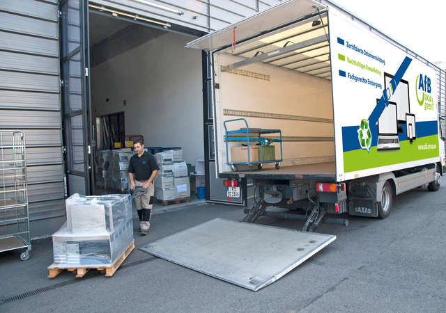 Pallets of laptops being loaded into a truck