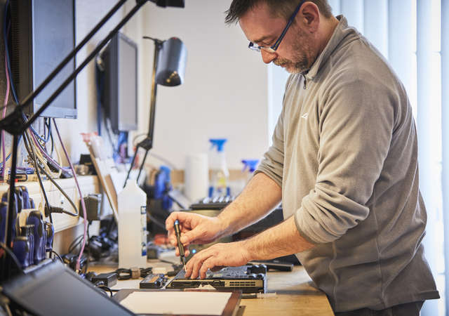 Man fixing a donated laptop